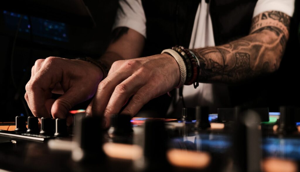 A closeup of a person playing songs and DJing - good for party-related categories